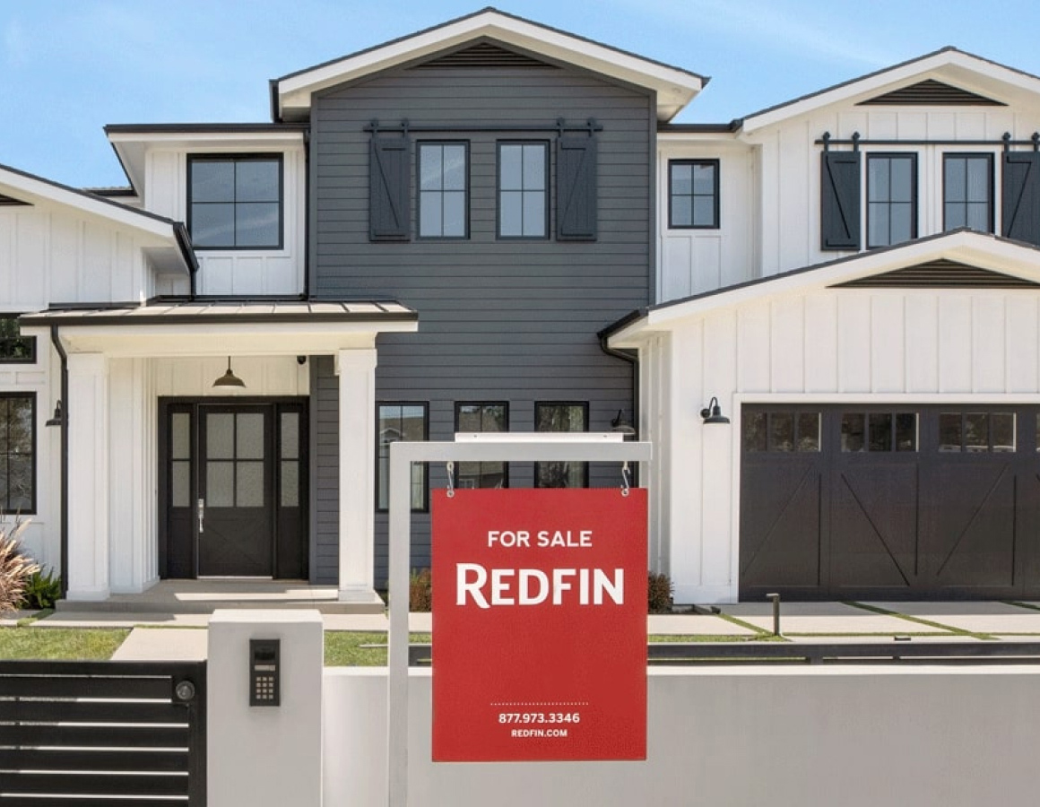 Redfin for sale yard sign in front of a house.